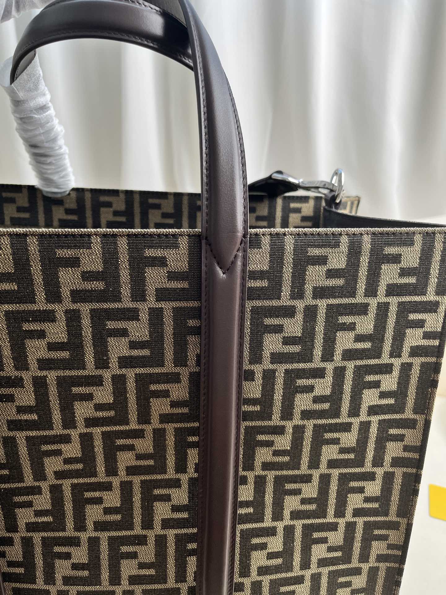 FENDI spacious tote bag in recycled jacquard fabric featuring gray and black FF motif. Featuring fabric-lined interior compartments, interior zip pocket and silver-tone hardware.