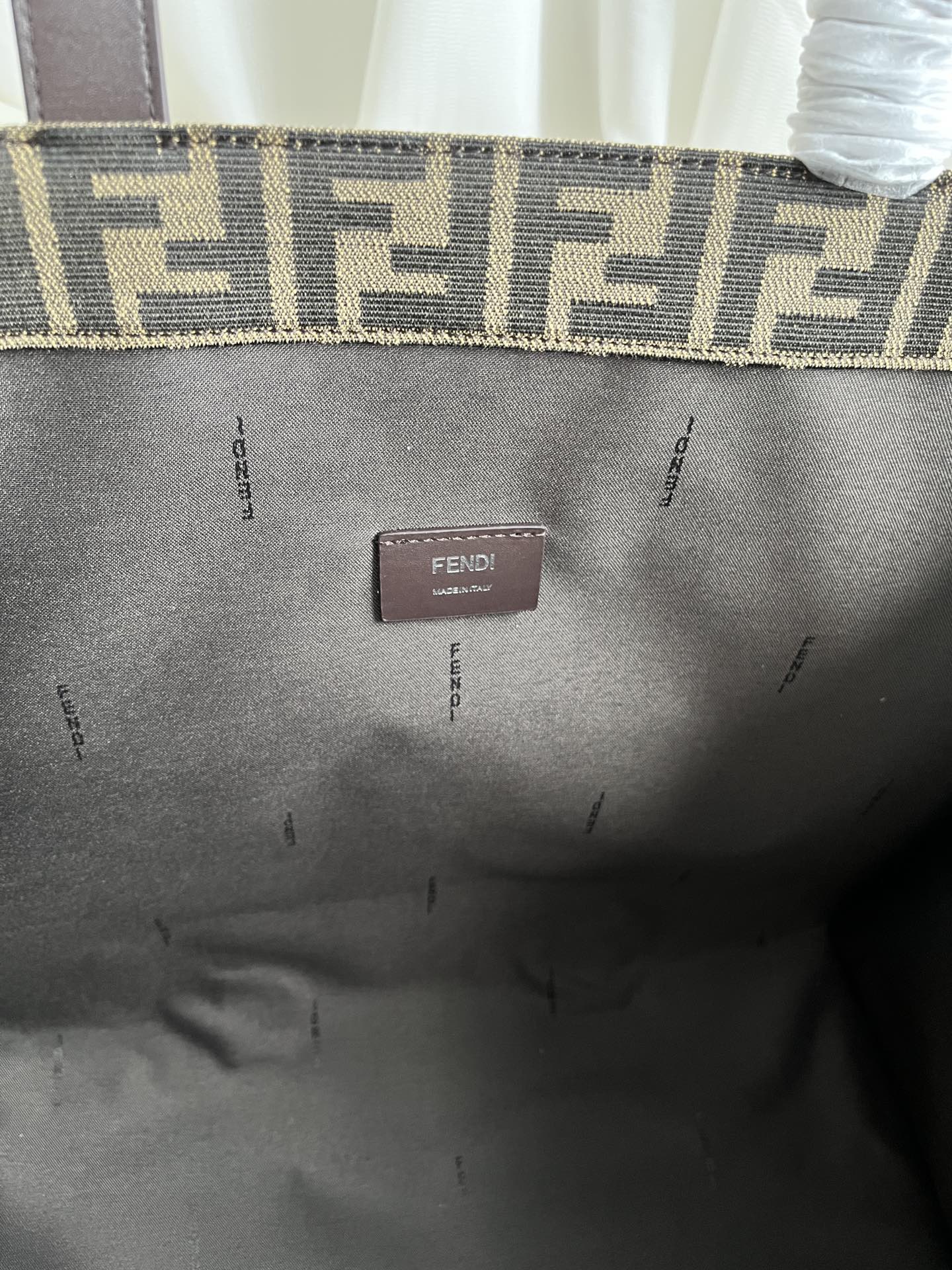 FENDI spacious tote bag in recycled jacquard fabric featuring gray and black FF motif. Featuring fabric-lined interior compartments, interior zip pocket and silver-tone hardware.